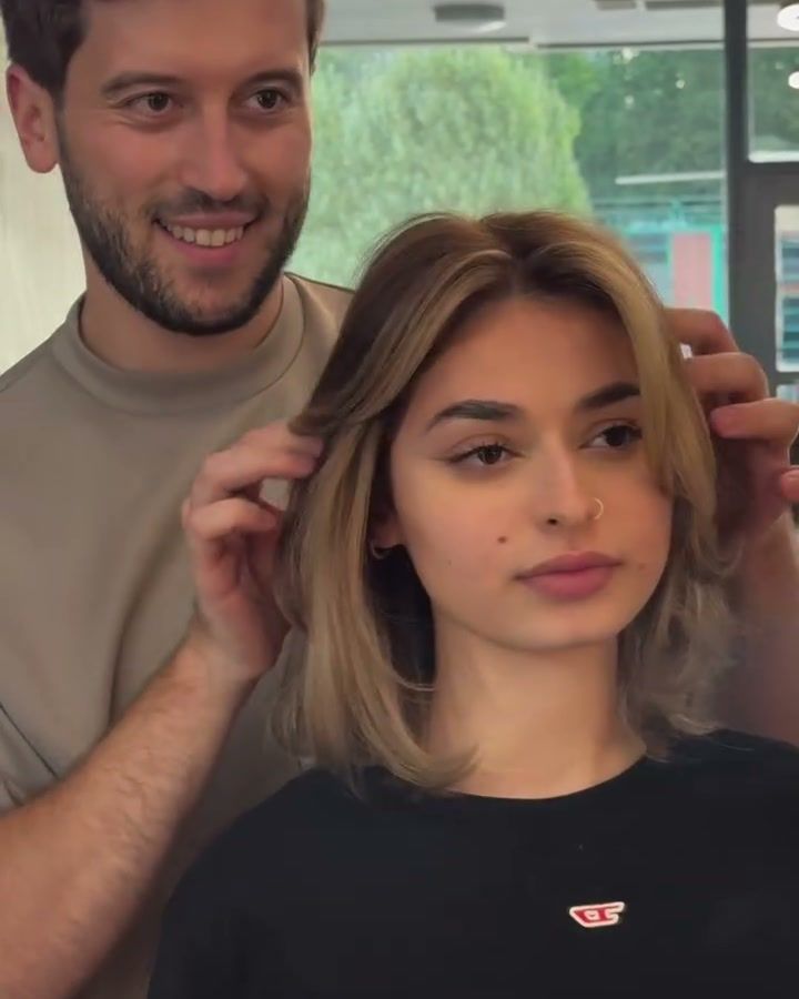 A beige blonde bob with bangs, Han behind the chair